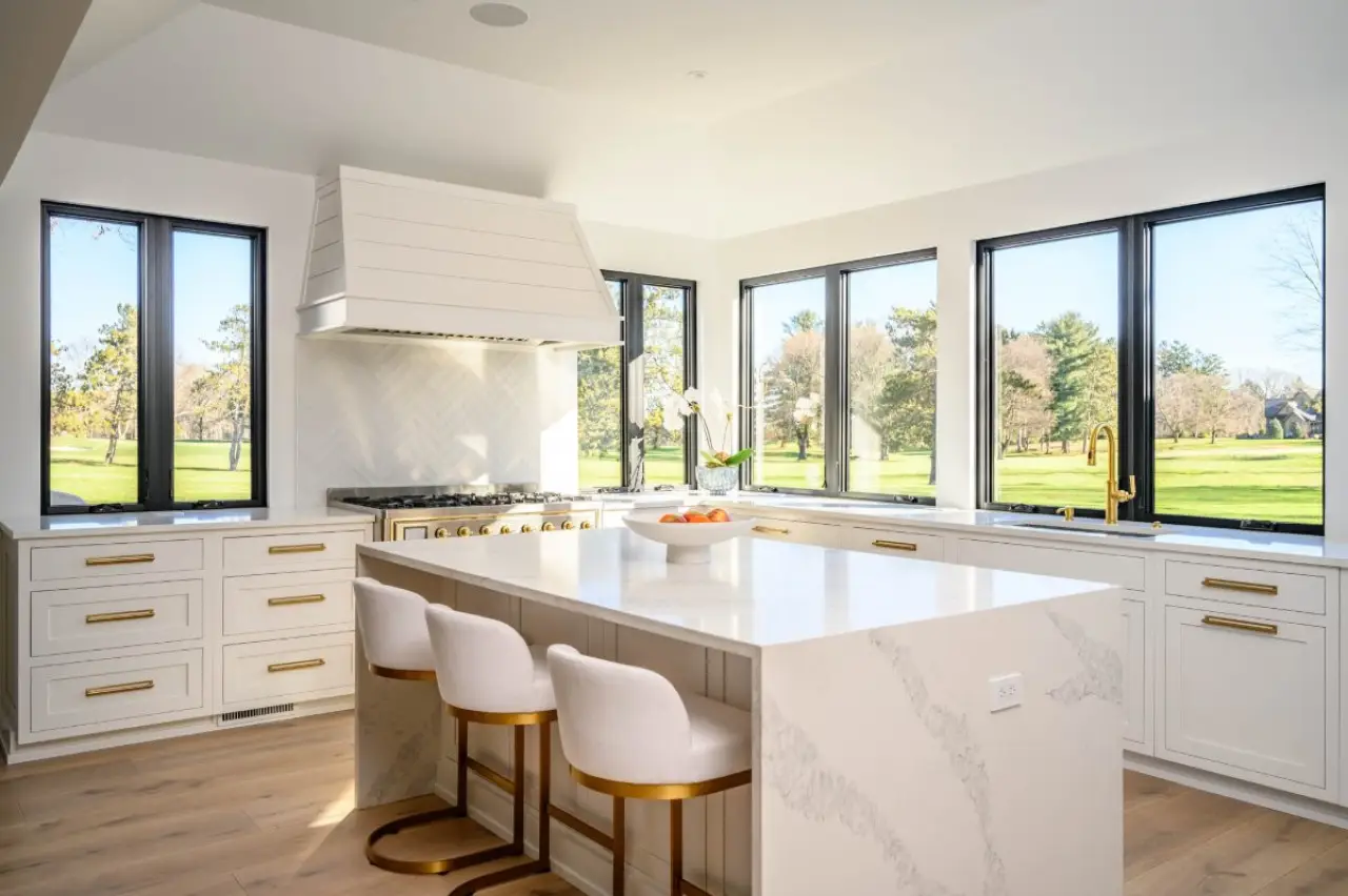 A newly remodeled kitchen with windows and white cabinets.