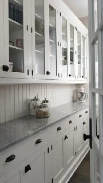 White kitchen cabinetry and marble countertops
