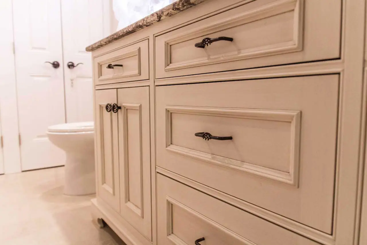 Glazed inset bathroom vanity with granite countertop and oil-rubbed bronze hardware.