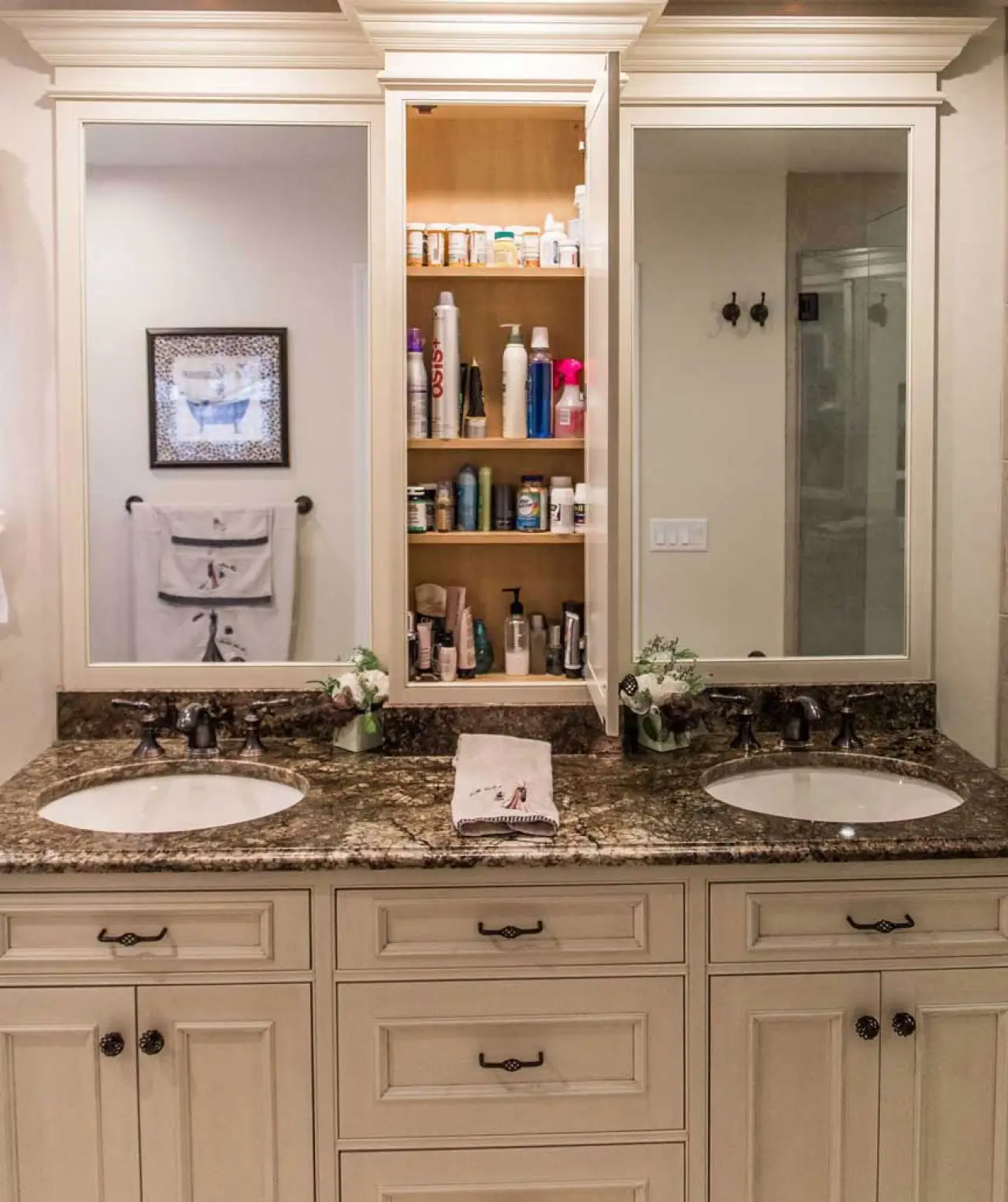 Earth-tone double vanity with granite countertop and open mirrored medicine cabinet.