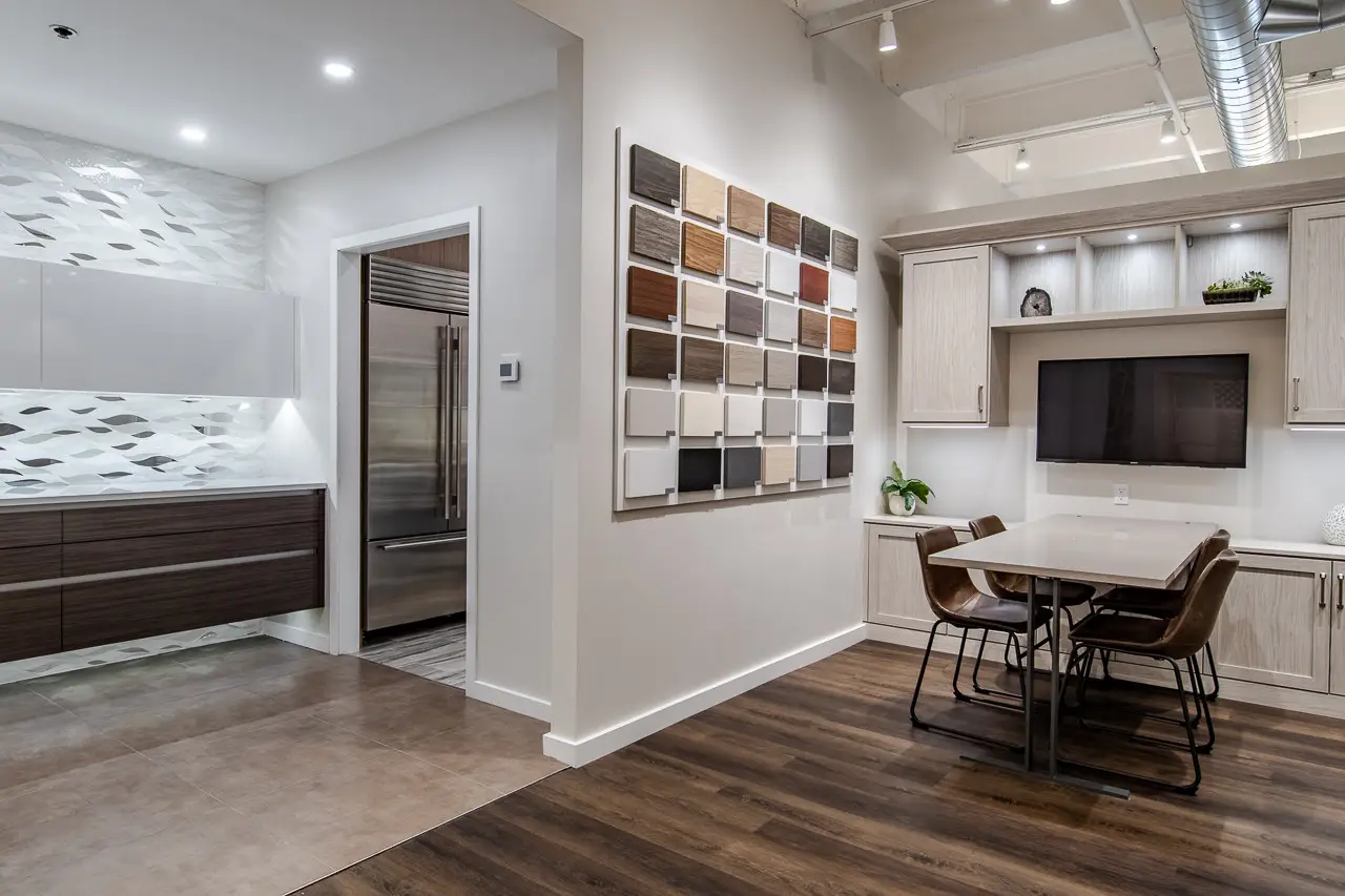 Kitchen showroom with cabinetry displays, material samples, and consultation table.