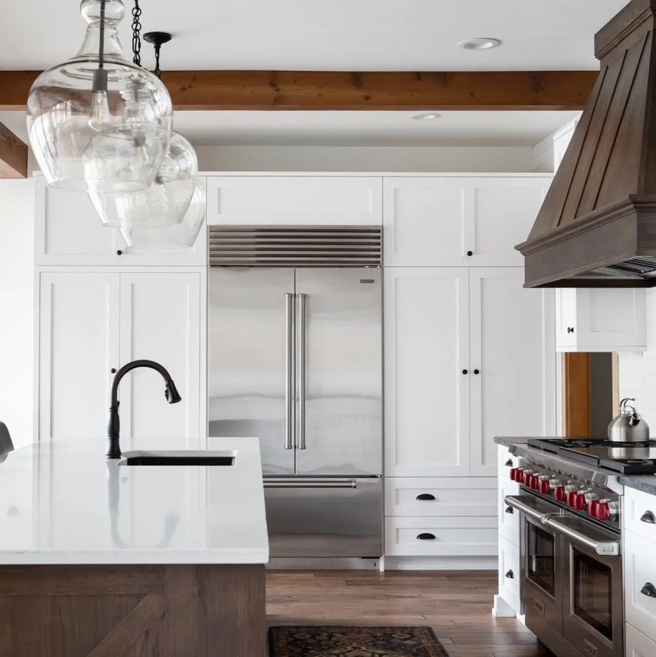 Modern kitchen with white cabinetry, quartz countertops, and custom design details.