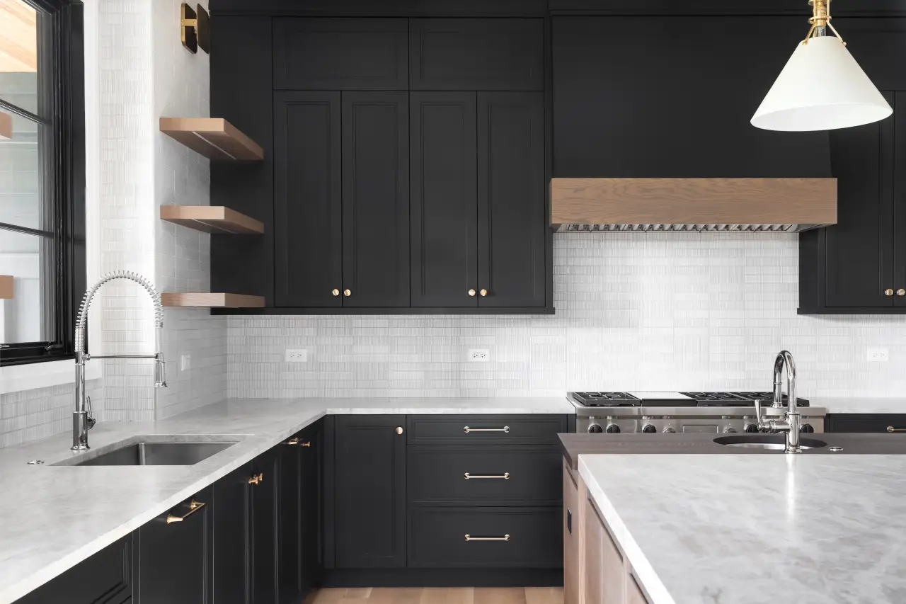 Modern kitchen with black cabinets, marble countertops, and open wooden shelves.