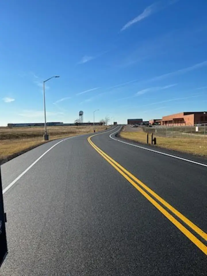 curved line striping on a freshly paved road