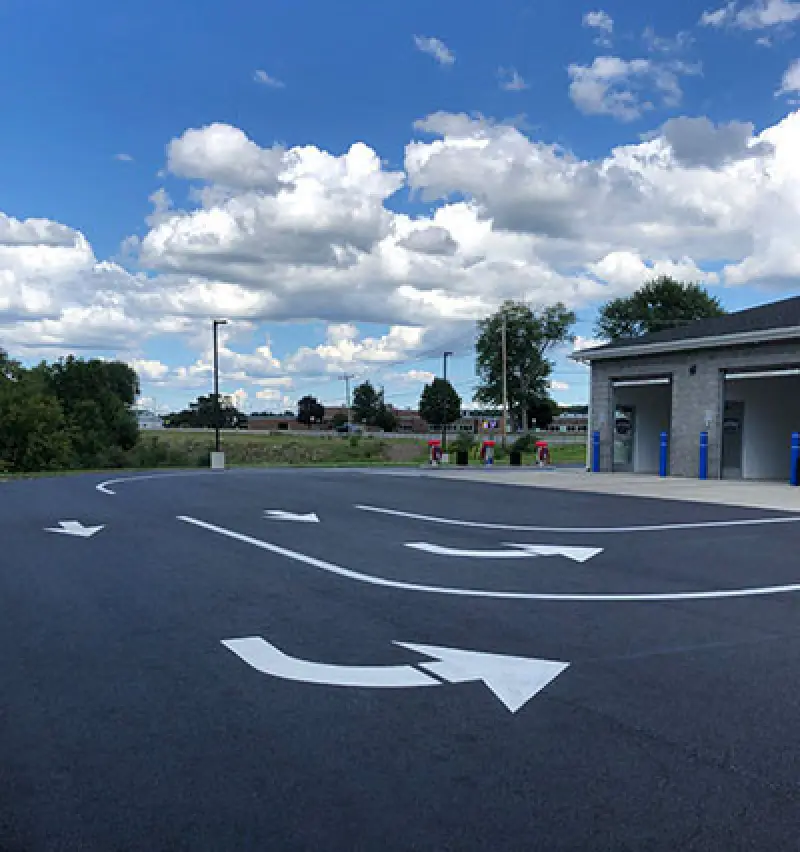 white arrows and lines in car wash parking lot