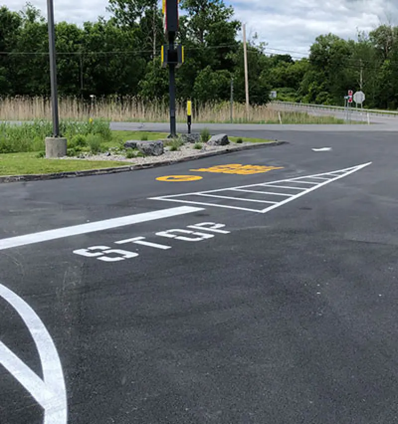 white and yellow paint with lines, stop sign, and drive thru sign