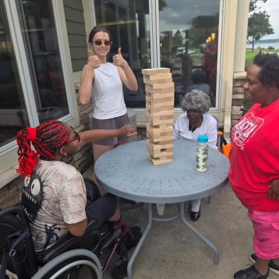Participants gather around a table to play Jenga