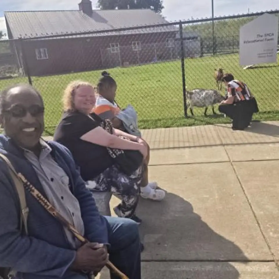Registrants in the Schofield Adult Day Health Care Program look on as a goat takes snacks at the SPCA.