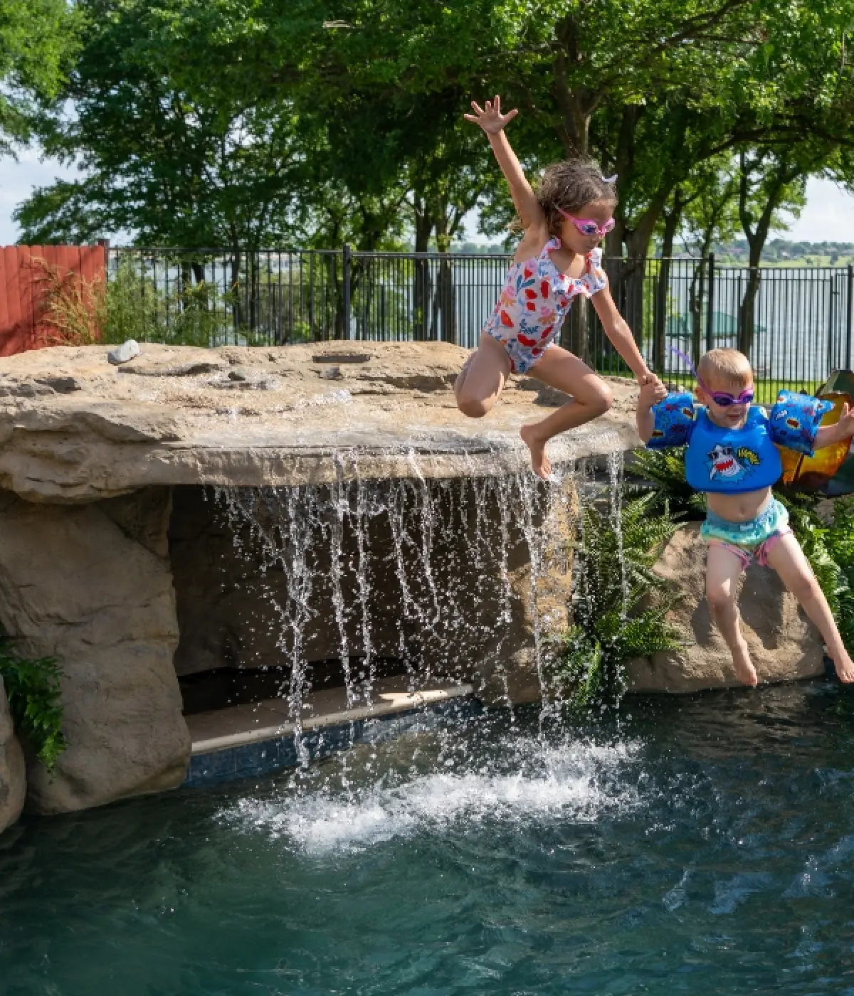 backyard pool party with waterfall