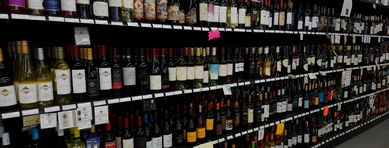 A variety of wine bottles arranged on shelves in a store.