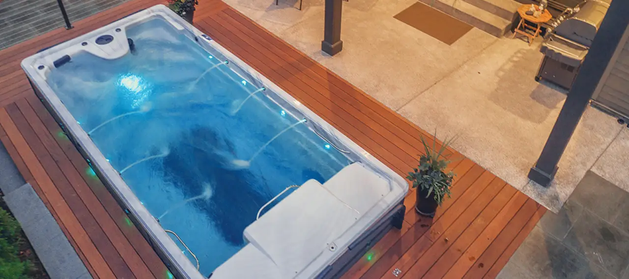 pdc spas truswim swim spa with cascading water spouts on decking surrounded by tiled patio