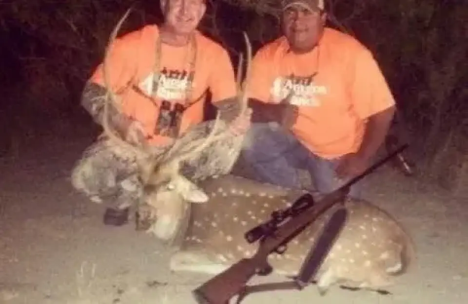 two hunters in orange shirts with trophy