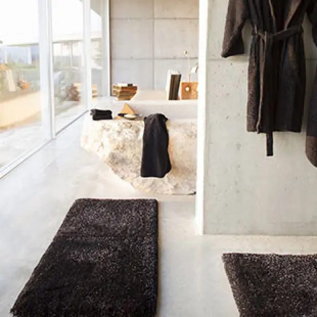 brown bath rugs in white bathroom