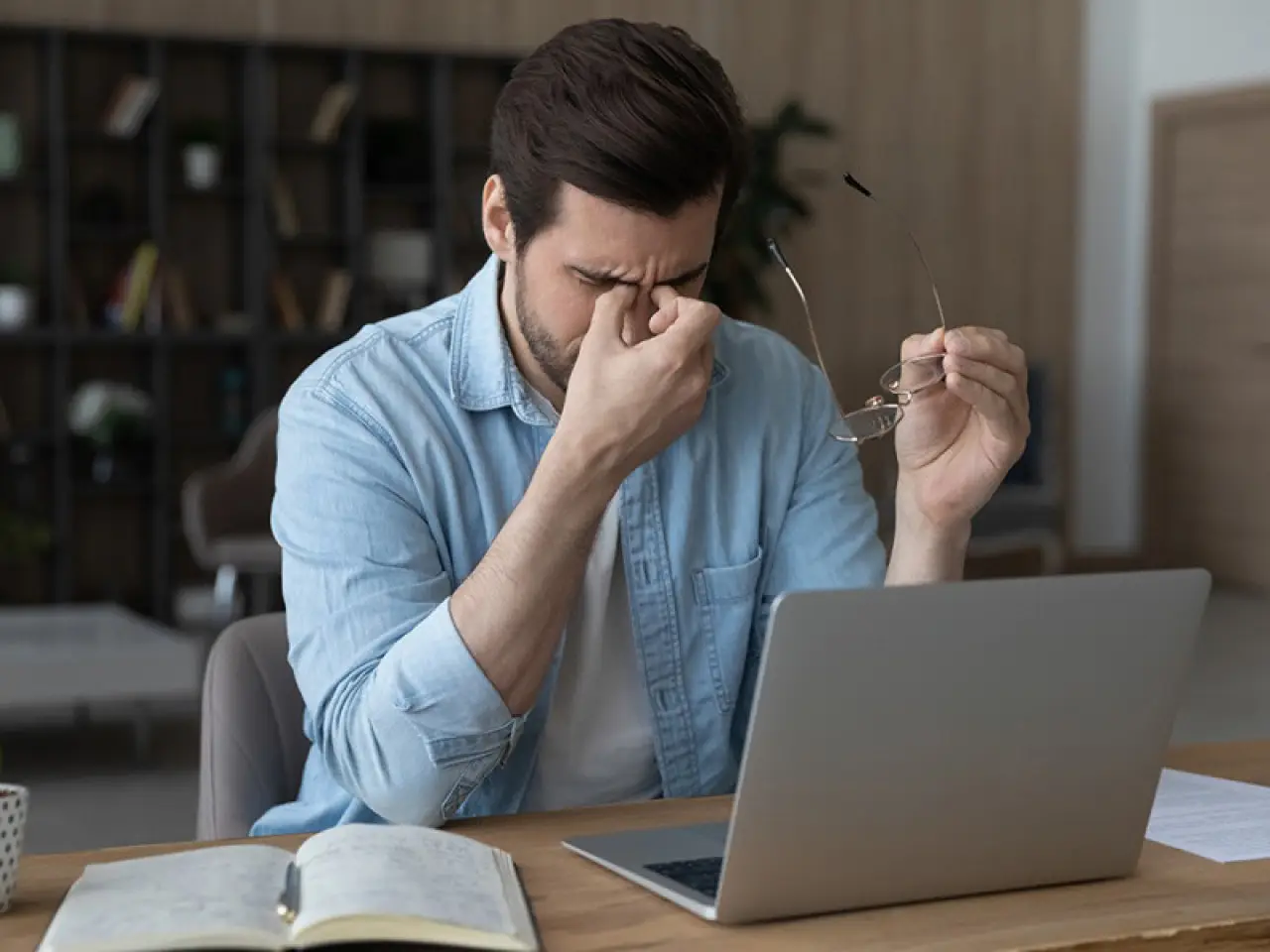 man with vestibular and balance issues holding his nose in pain