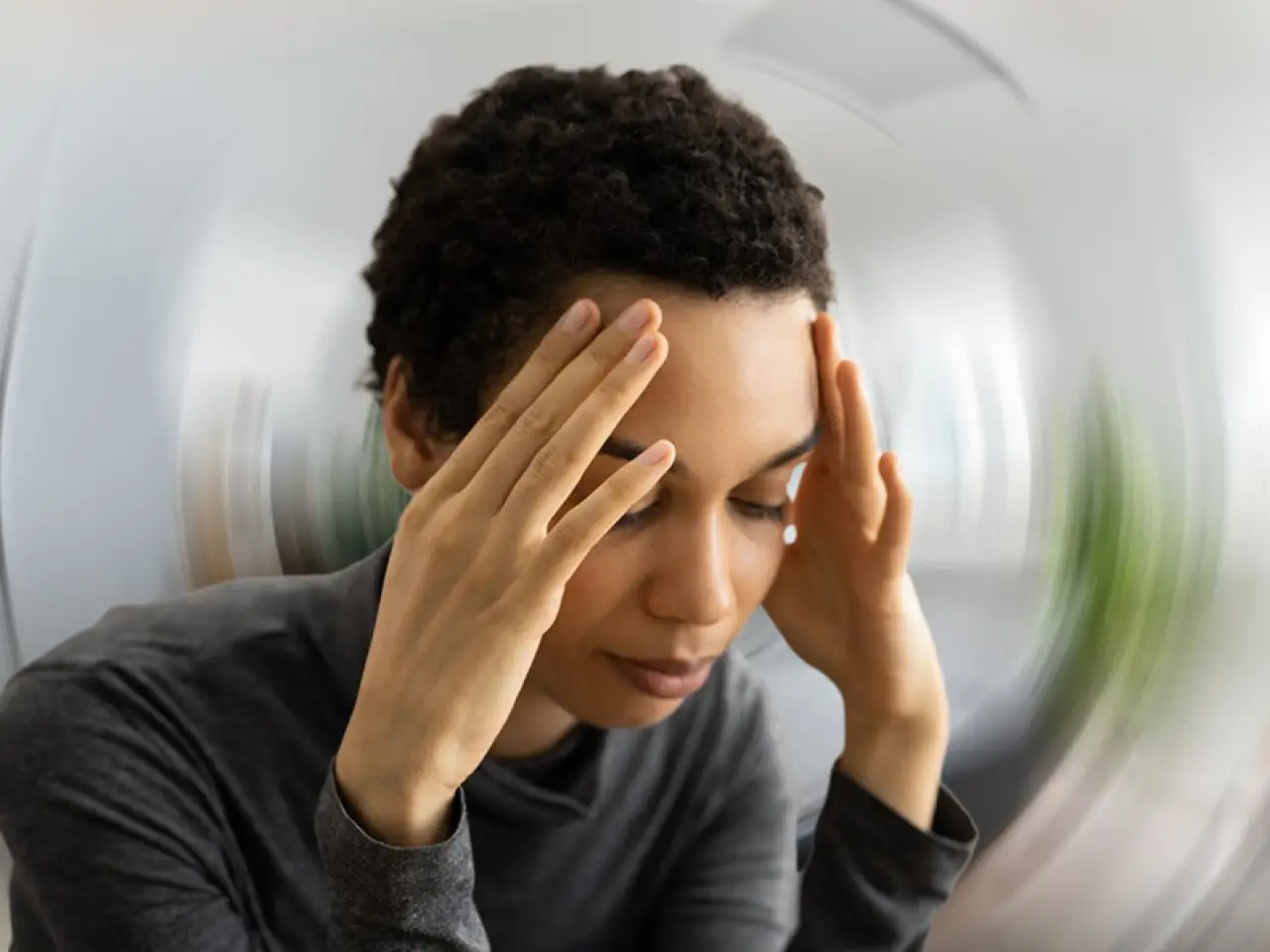 woman holding her head from dizziness