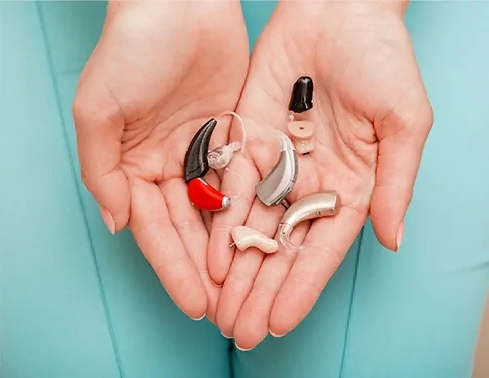 hands holding hearing aids