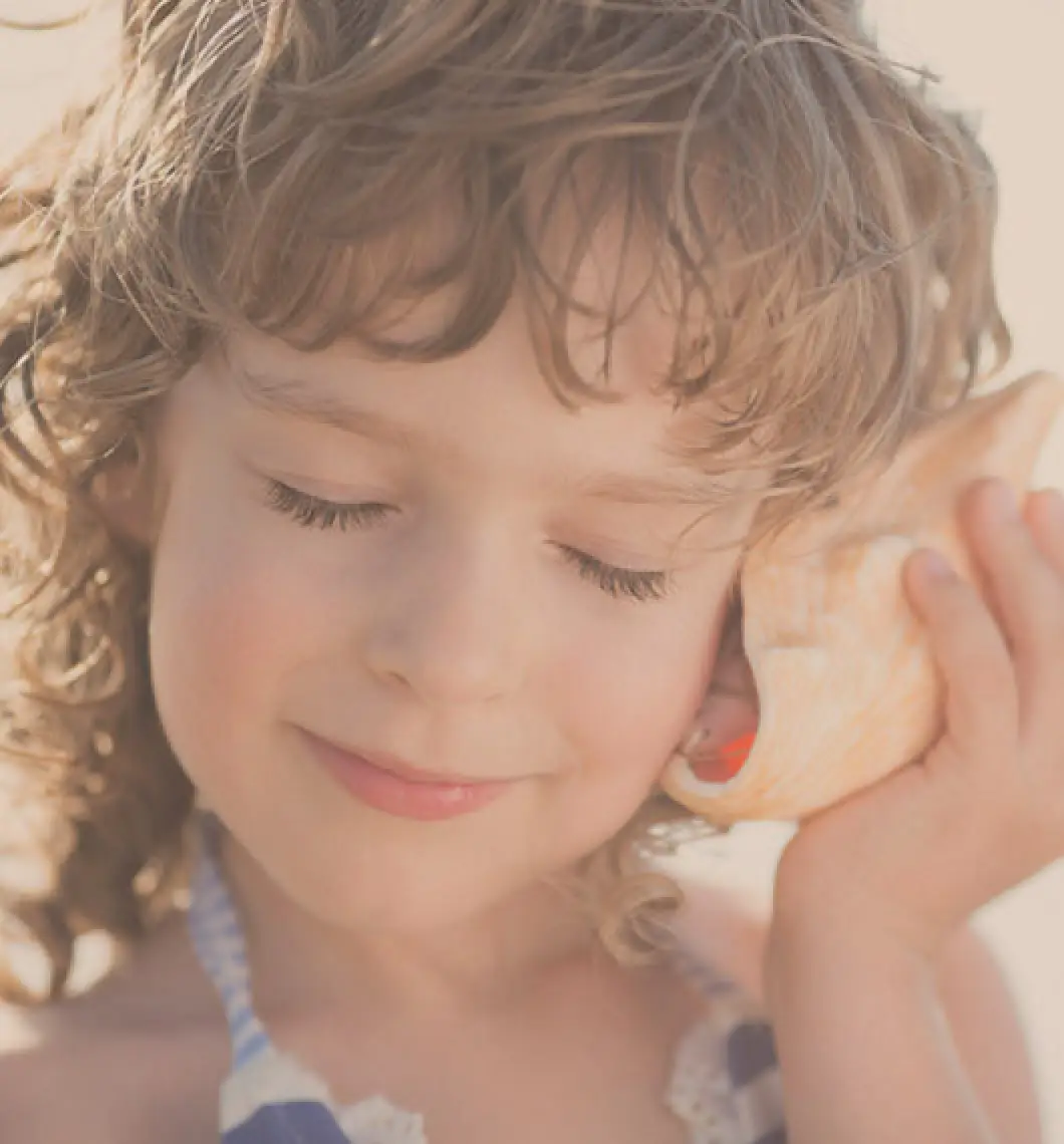 child listening to seashell