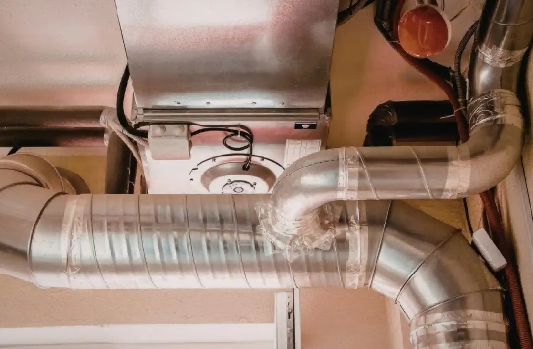 Metallic air ducts connected to a furnace system, with visible tape sealing the joints.