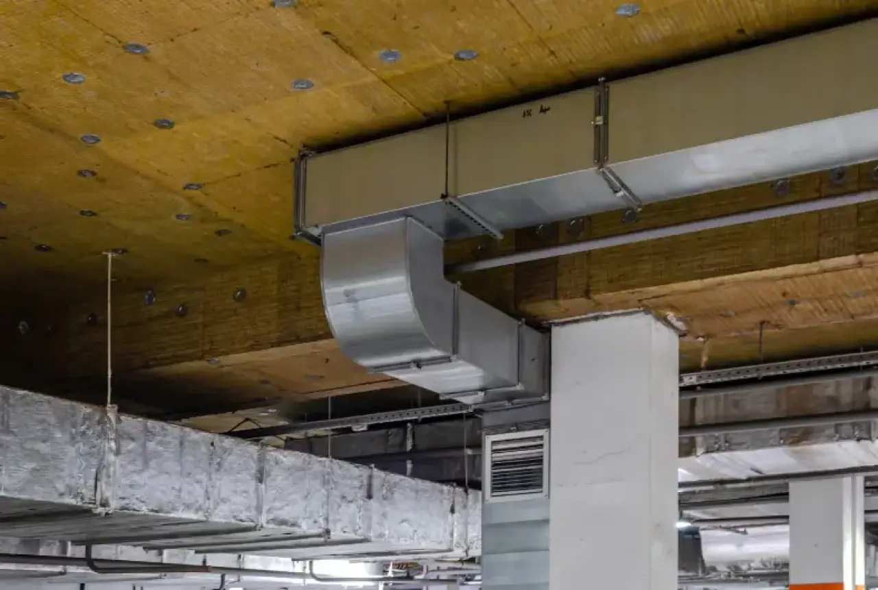 Rectangular metal air ducts attached to a ceiling in an unfinished building interior.