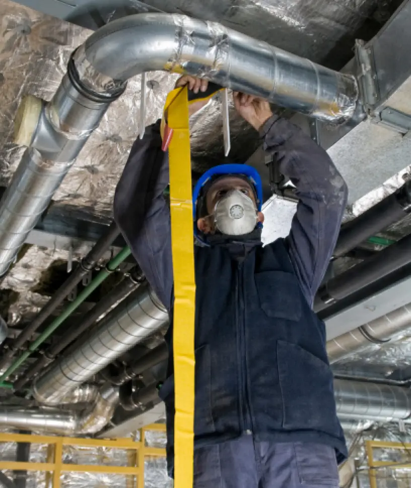 A service worker sealing a commercial dryer vent.