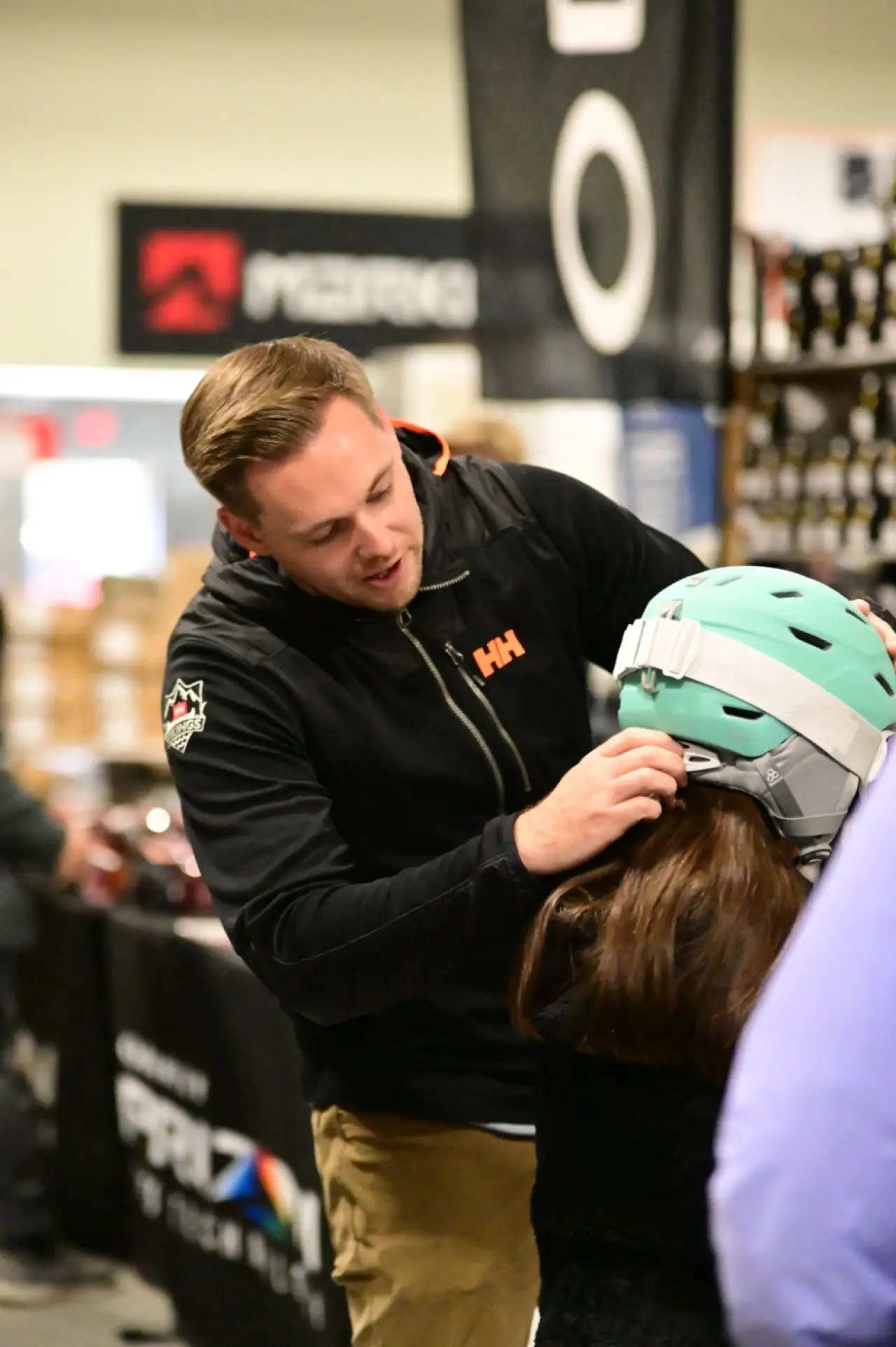 Ski Expo staff member adjusts a customer's helmet for a proper fit.