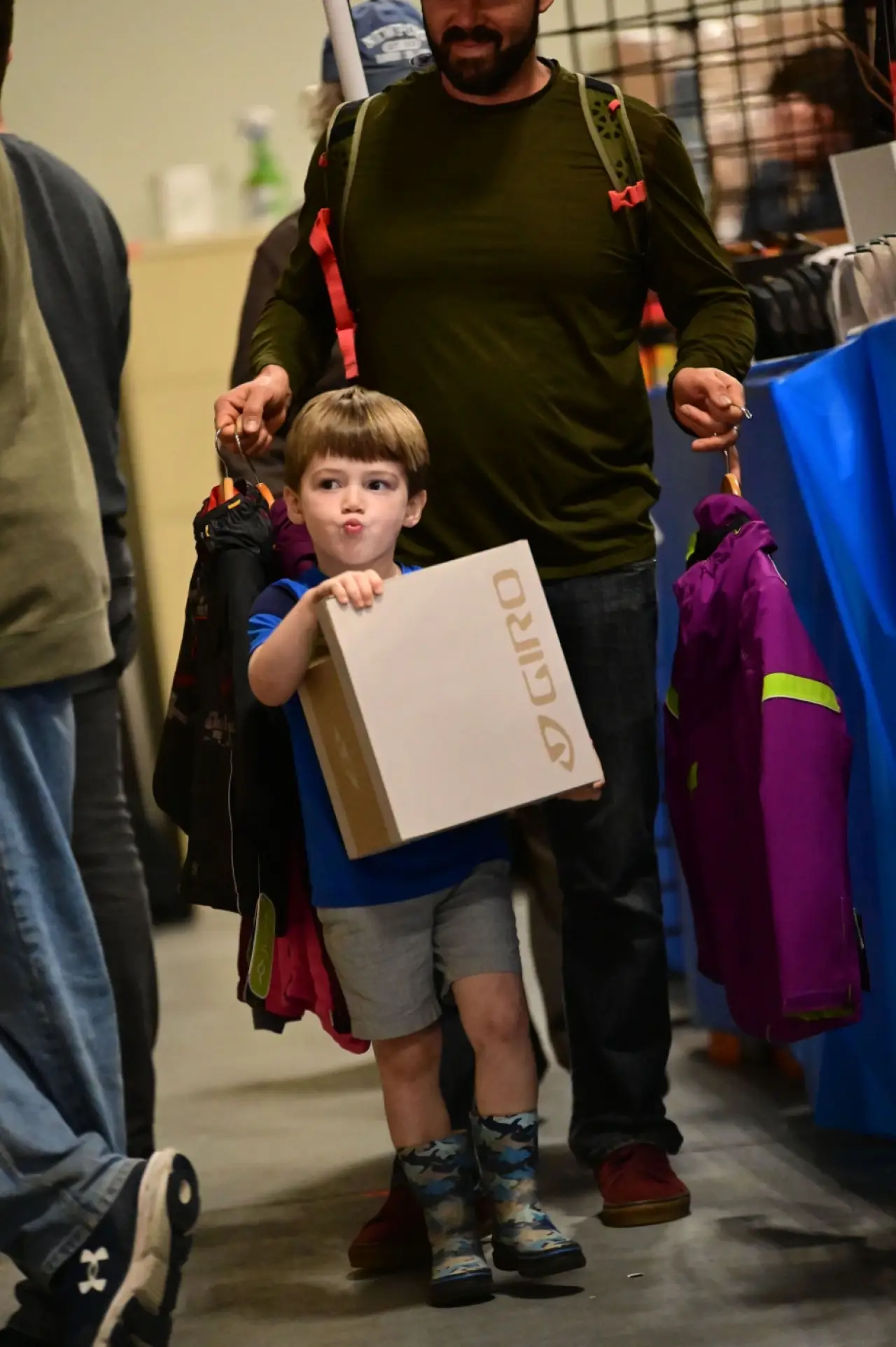 Father and son carry winter gear through the Country Ski Expo.