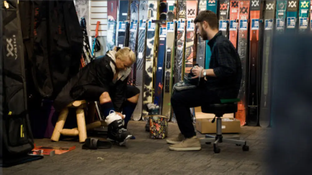 worker helping a woman with a fitting appointment at Westwood Country Ski