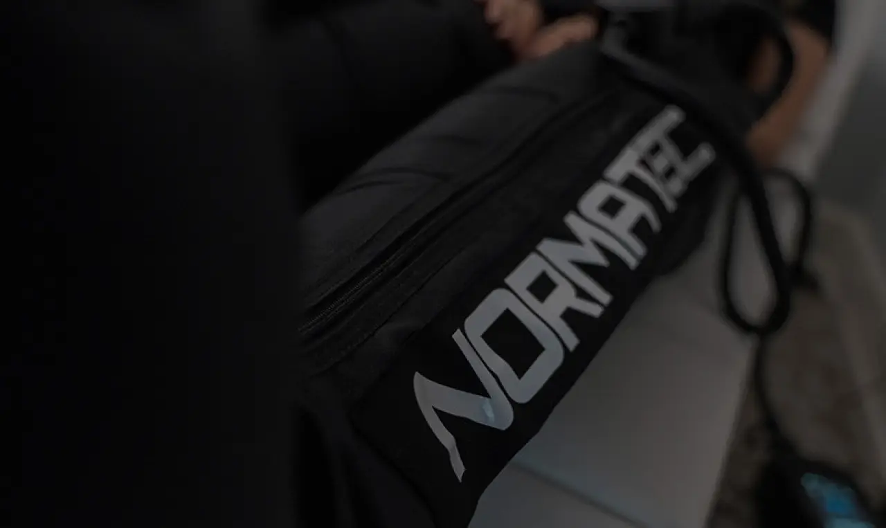 Close-up of a black bag with the white NORMATEC logo visible on its side.