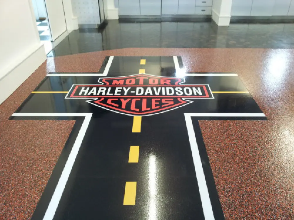 Harley-Davidson logo on a cross-shaped road graphic on a speckled showroom floor.