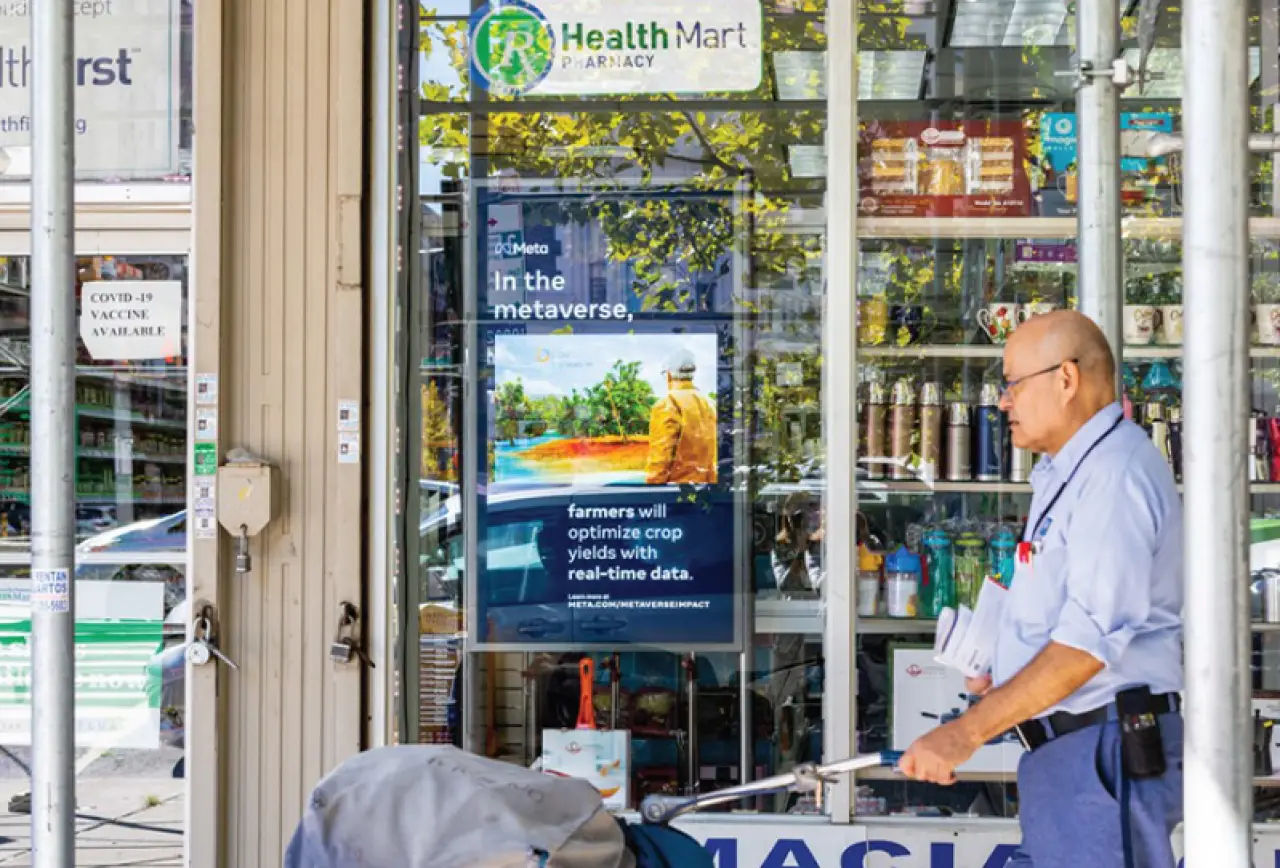 custodial man walking by digital signage