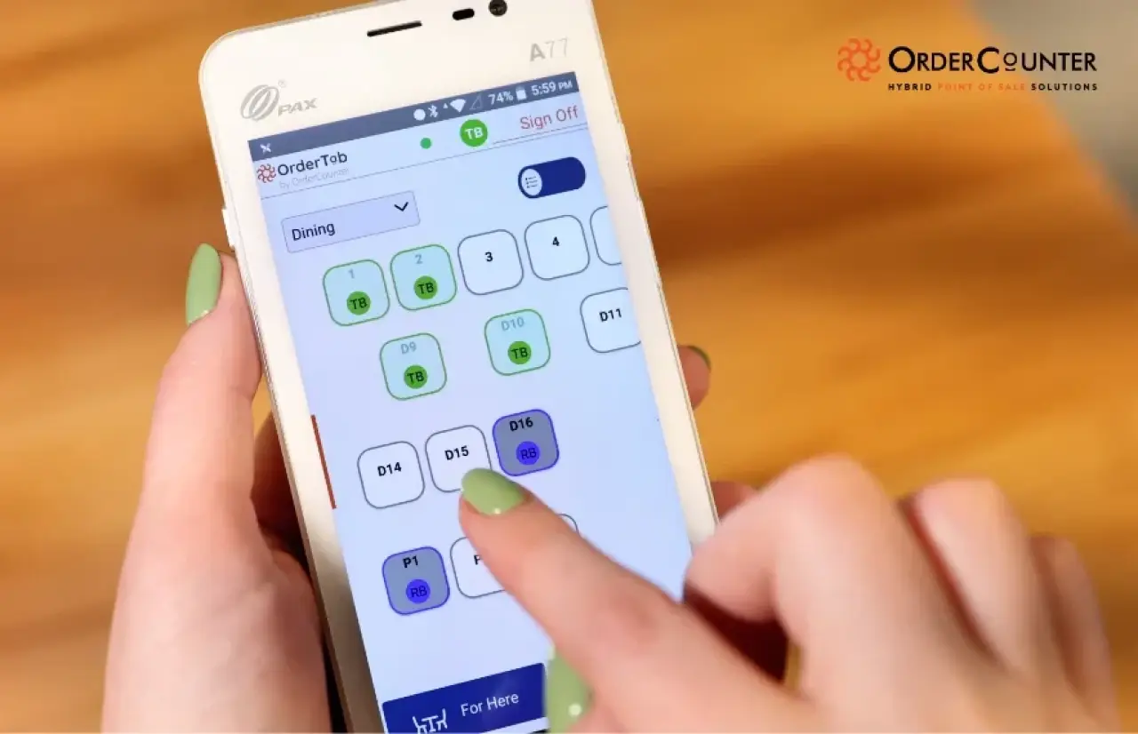Hand selecting a table in OrderCounter on a handheld POS device.