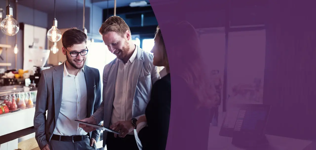 three professionals surrounding a tablet