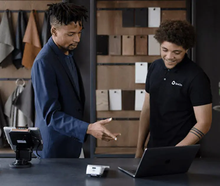 two men analyzing business metrics by pos system and laptop