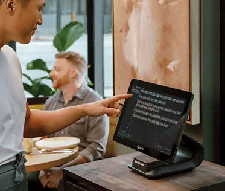 man at restaurant tapping pos system