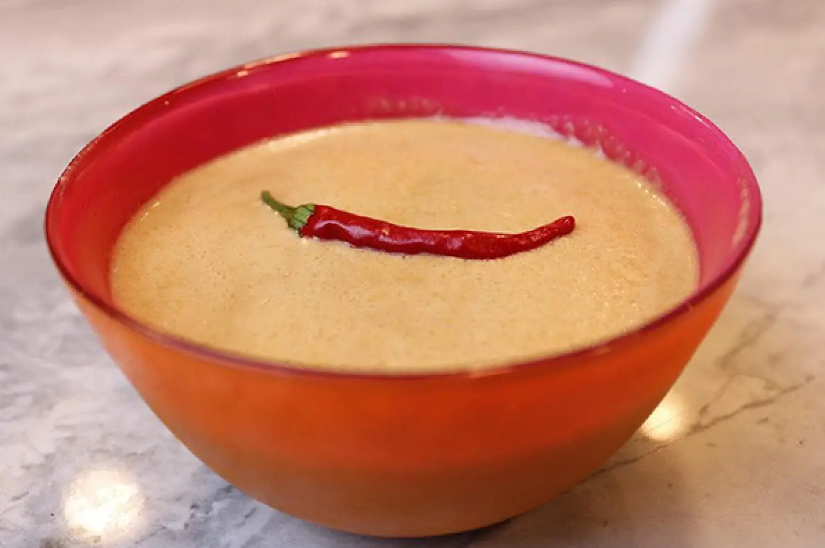 Sesame garlic ginger dressing in a red bowl with a chili garnish.
