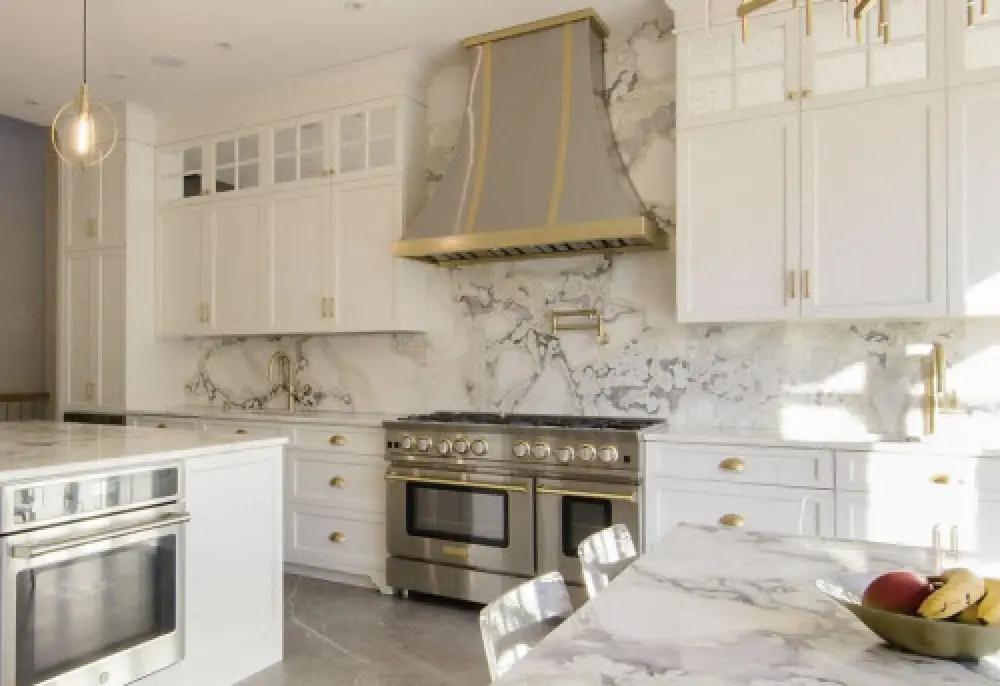 bright kitchen with stainless steel appliances and a marble backsplash