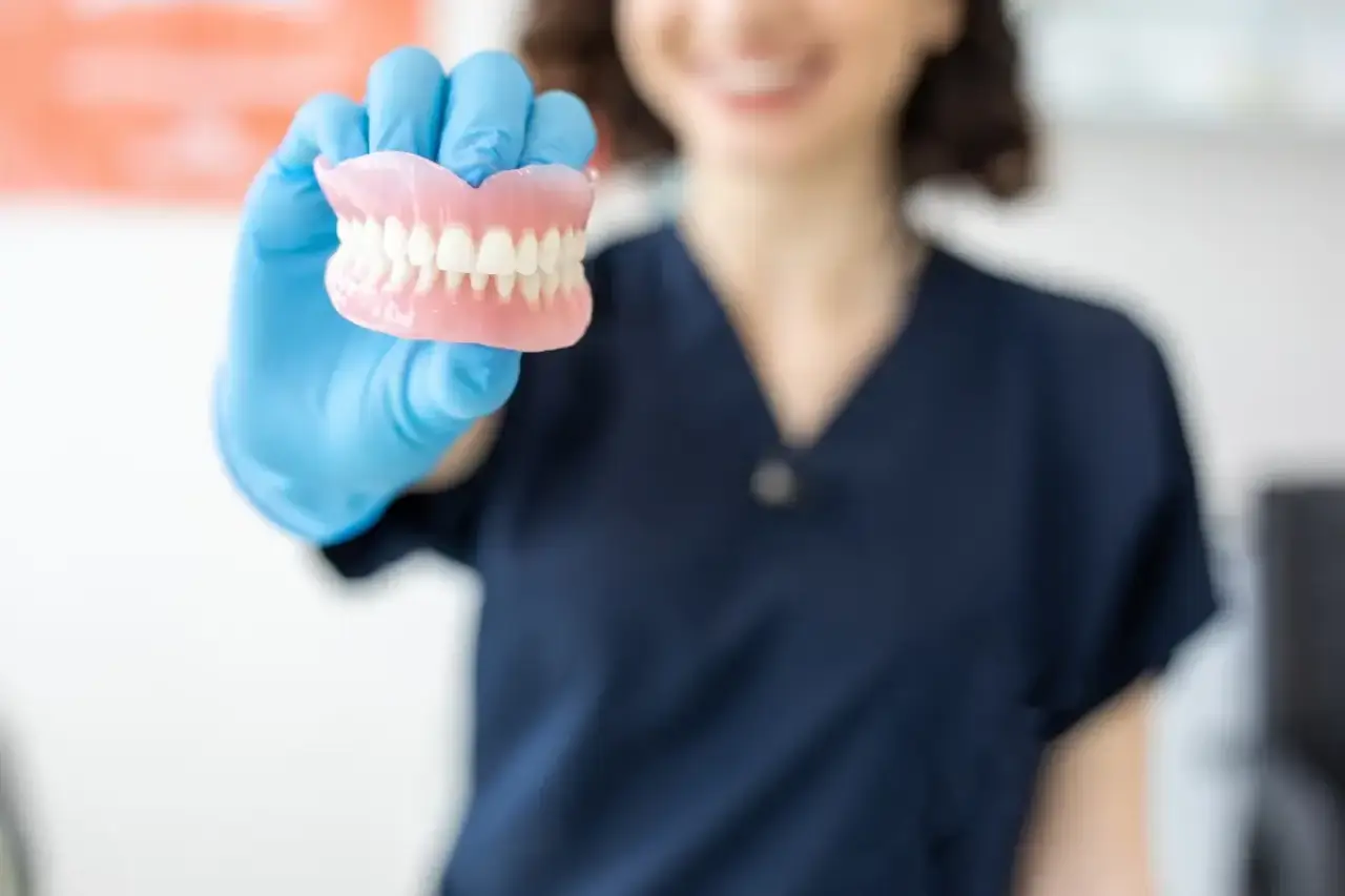 Woman holding porcelain teeth