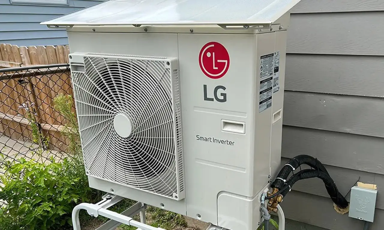 Outdoor LG Smart Inverter air conditioning unit mounted next to a gray house with visible wiring.