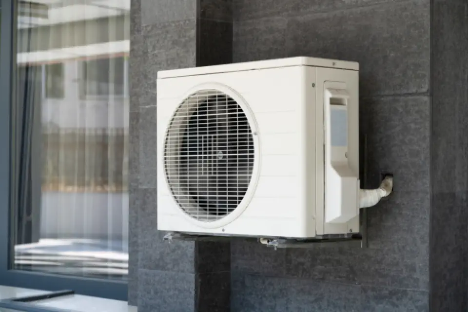 Outdoor heat pump unit mounted on a wall
