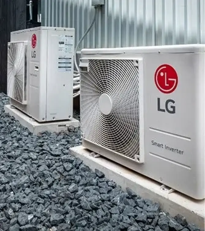 two outdoor LG Smart Inverter AC units placed on a gravel surface