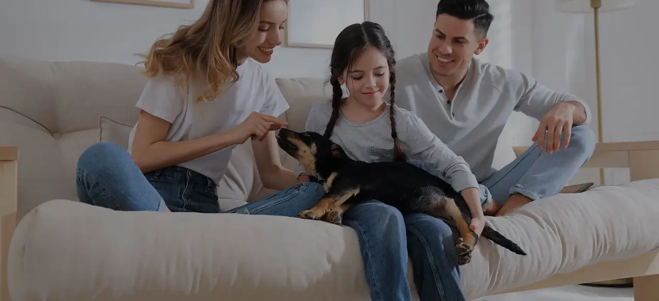 family and dog sitting on couch