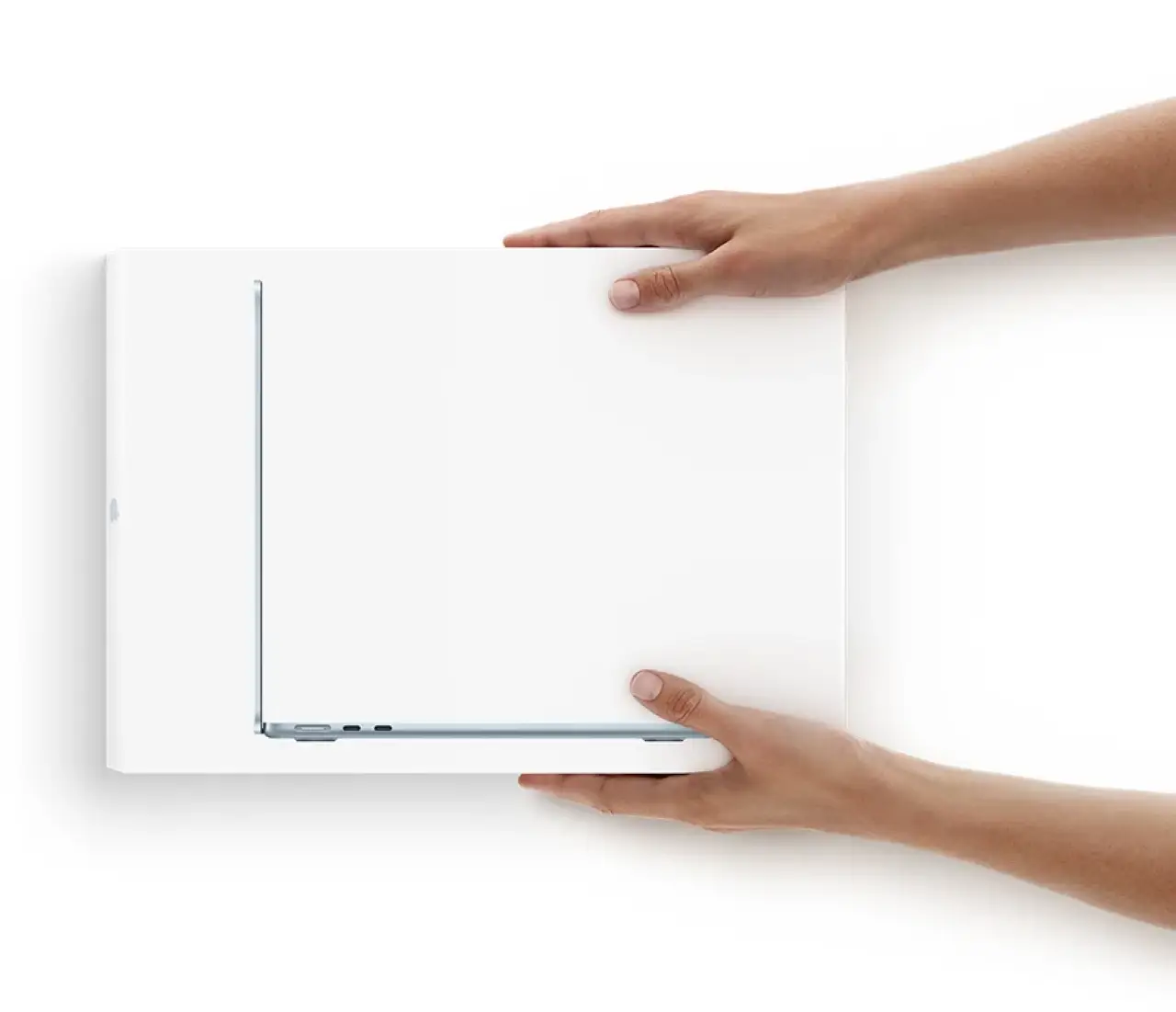 Hands holding a boxed MacBook Air