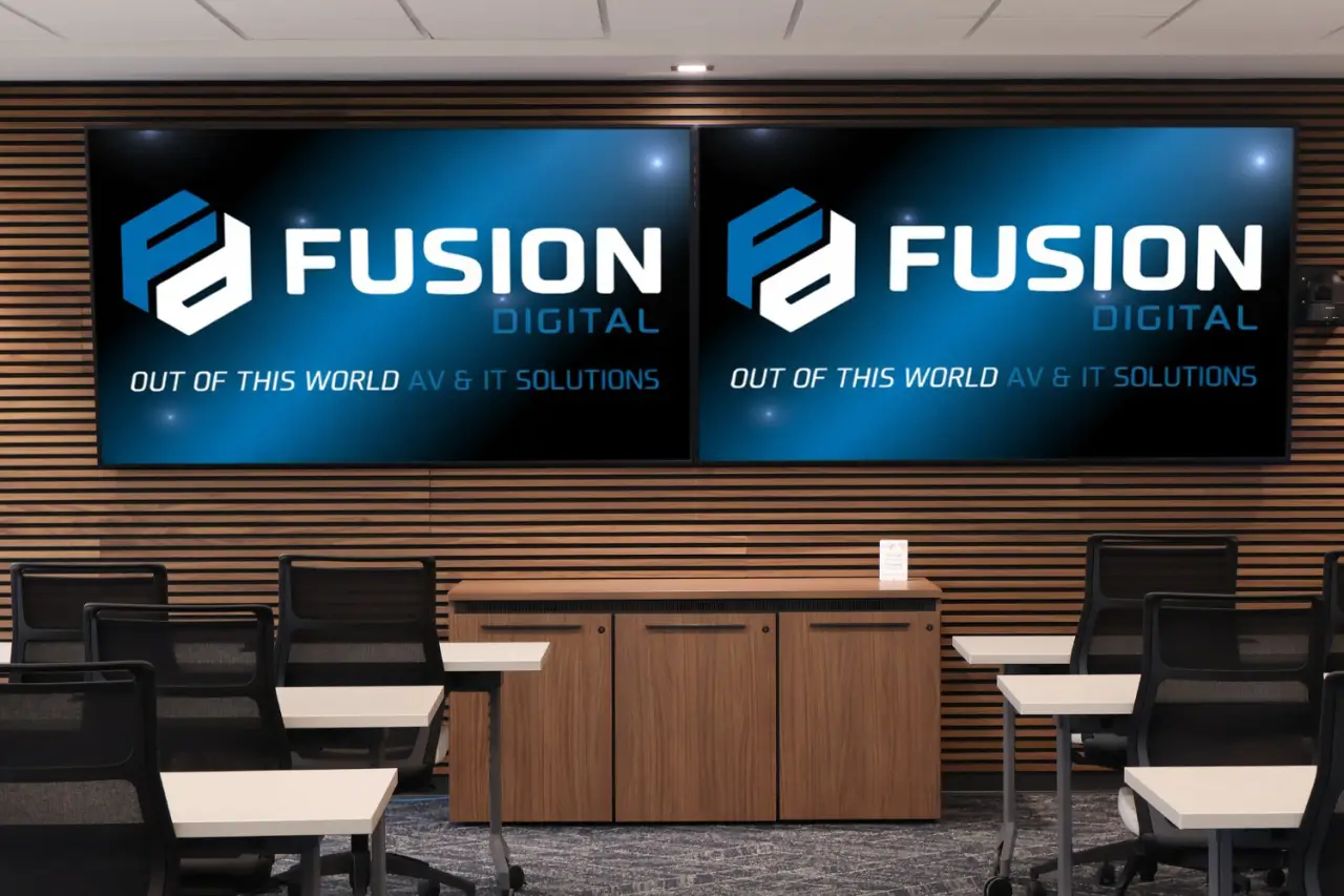 Conference room with chairs, desks, and two large screens displaying Fusion Digital branding.