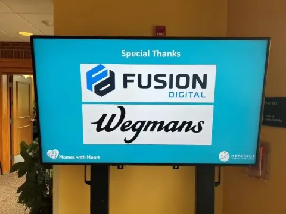 Digital screen thanking Fusion Digital and Wegmans, with Homes with Heart logo at the bottom.