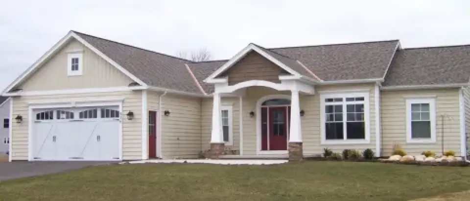 Single-story beige house with white trim, red front door, attached garage, and a front lawn.