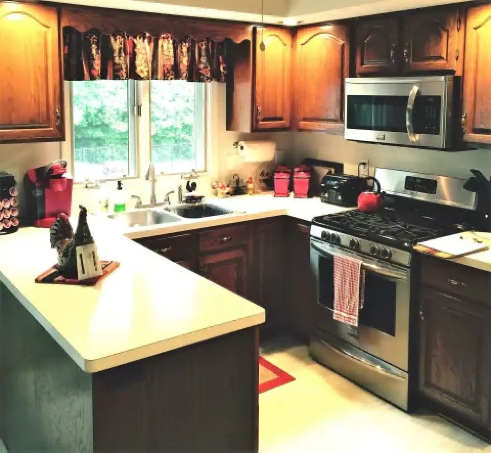 A kitchen with wooden cabinets, white countertops, and stainless steel appliances.