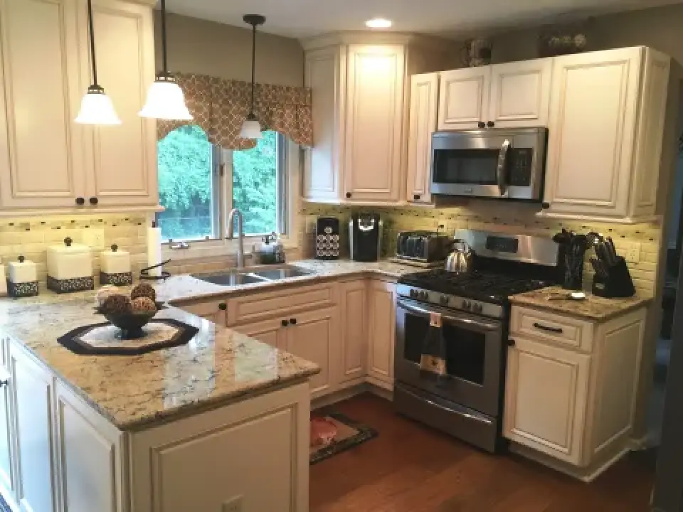 Bright kitchen with white cabinets, granite counters, stainless appliances, and hardwood floor.