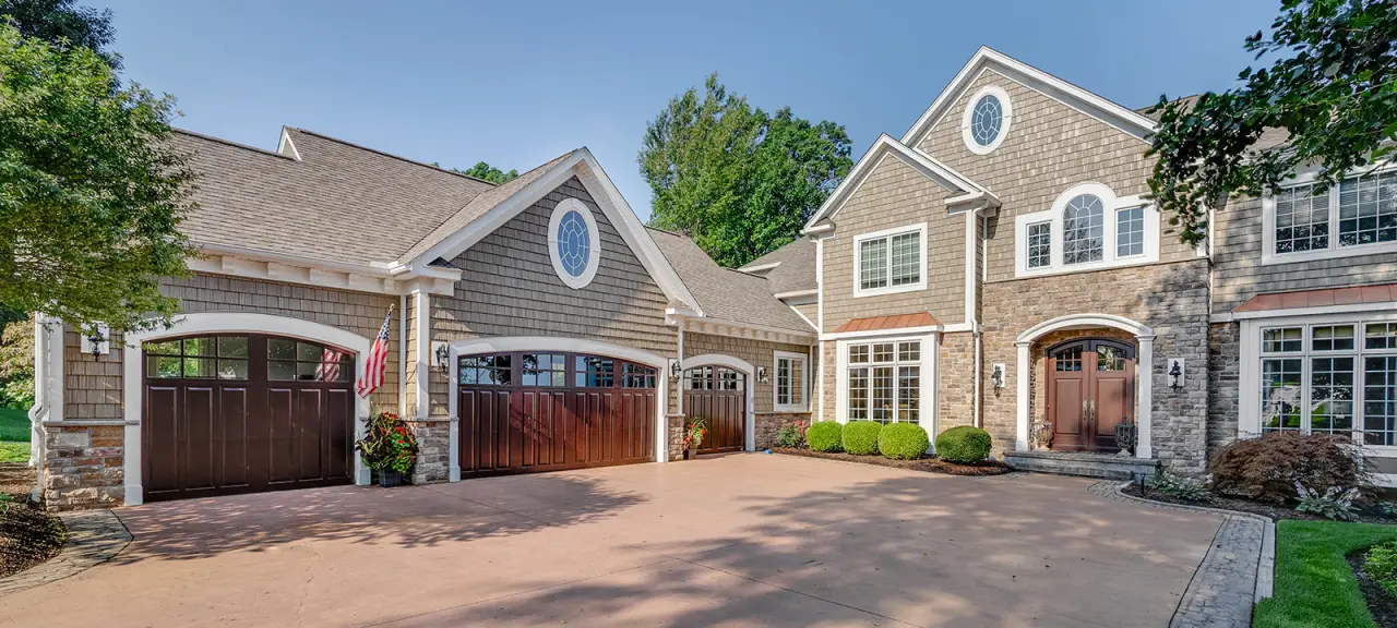 The front of a beige house with a four-car garage.