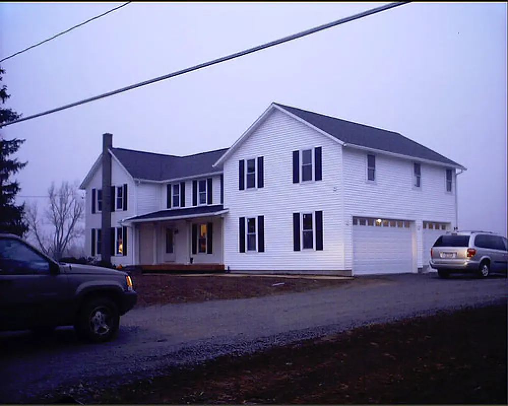 completed home addition on large white house by american custom inc