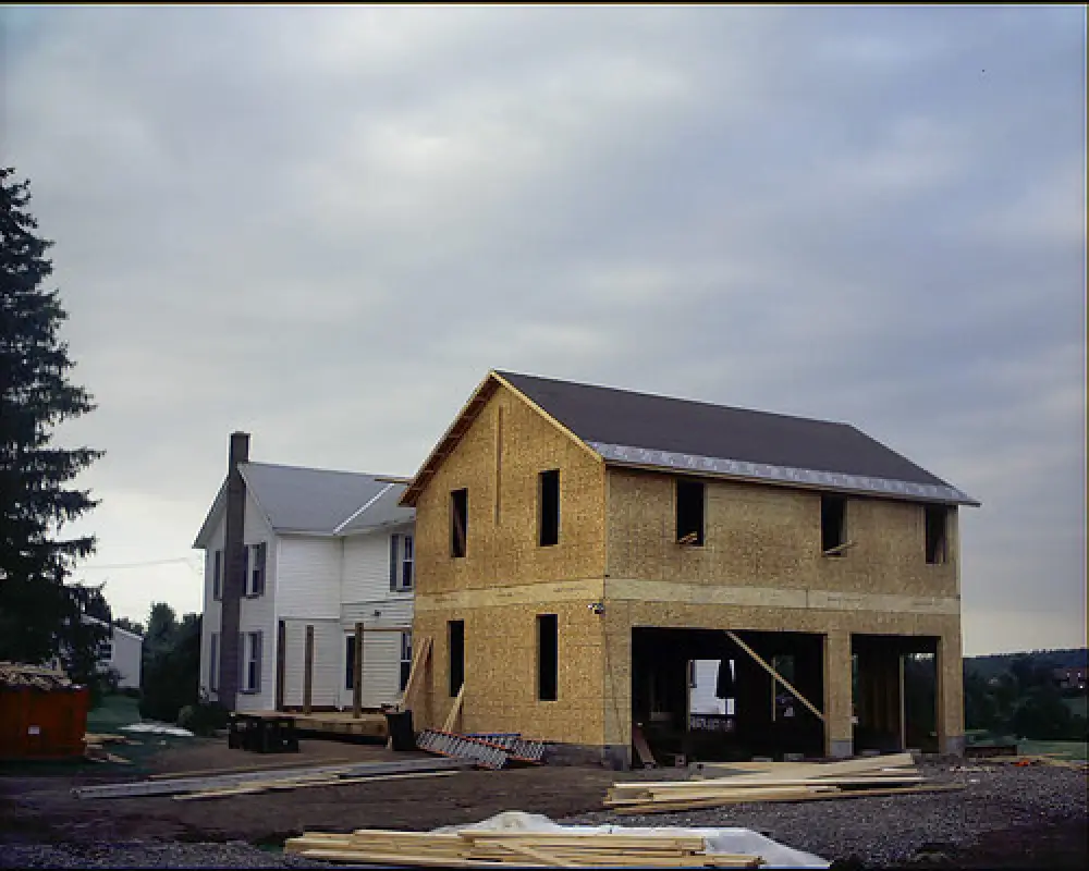 two story home addition being framed and roofed